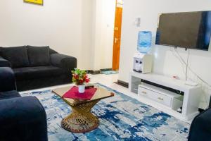 a living room with a couch and a tv at TWO BEDROOM APARTMENT BAMBURI Mombasa in Mombasa