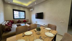 een woonkamer met een tafel en een bank bij Magnifique appartement Marrakech in Marrakesh