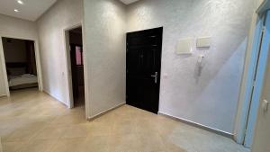 een hal met een zwarte deur in een kamer bij Magnifique appartement Marrakech in Marrakesh +37 foto's