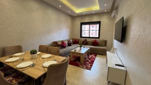 een woonkamer met een tafel en een bank bij Magnifique appartement Marrakech in Marrakesh
