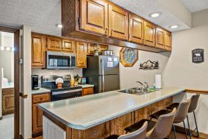 a kitchen with wooden cabinets and a stainless steel refrigerator at Lazy Dayz by Avada Properties in Pigeon Forge