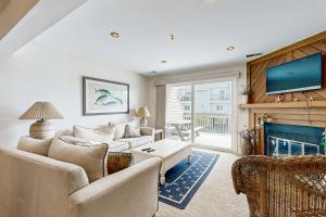 a living room with two couches and a fireplace at Indian Harbor Villas -- 31 Indian Harbor in Bethany Beach