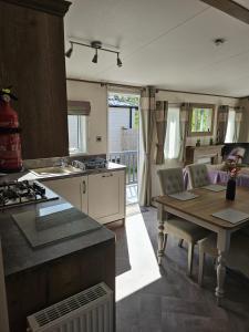 a kitchen with a table and a dining room at Still Waters Luxury Retreat with Hot Tub -Tattershall Lakes in Tattershall +13 photos