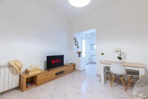 a living room with a tv and a dining table at Maria House, Jacuzzi e Patio in Olbia