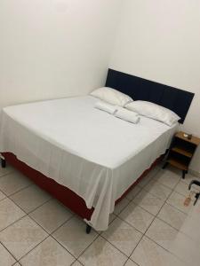 een bed met twee witte kussens erop bij Pousada 4 Estações in Maceió