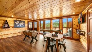 Un comedor con mesa de ping pong en una cabaña. en Luxe Memory Maker View Indoor Pool Games Sleeps 20, en Sevierville