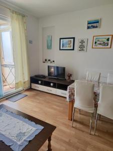 a living room with a tv and a table and chairs at Apartmani Marijela in Orebić