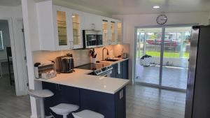 a kitchen with a counter and chairs and a clock at Waterside Serenity in Hudson