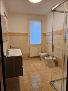 キオッジャにあるCasa al Teatroのトイレ、洗面台、シャワー付きのバスルーム +2枚の写真
