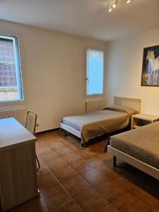 キオッジャにあるCasa al Teatroのベッドが2つと窓のある部屋