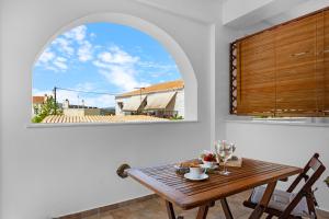a dining room with a table and an arch window at Spetses Center Comfy Apartment in Spetses