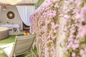 a wall covered in pink flowers next to a chair at Maria House, Jacuzzi e Patio in Olbia