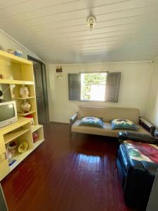 Una sala de estar con un sofá y una ventana. en Casa Aconchego, en Santa Teresa