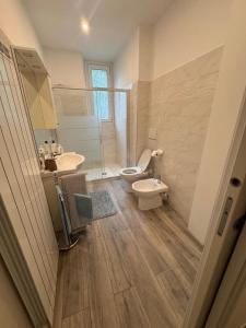 Un baño con inodoro, lavabo y espejo. en Casa Fiordaliso, en Lecco