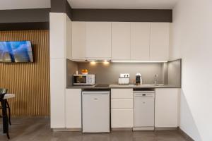 a kitchen with white cabinets and a microwave at Apartamentos enfrente del Museo Dalí - Serena Stays in Figueres