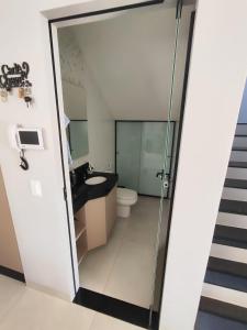 a bathroom with a toilet and a glass shower door at Casa para período Bahia Farm Show valor negociável in Luis Eduardo Magalhaes