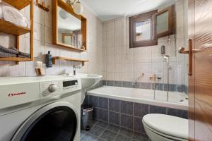 a bathroom with a washing machine and a tub at Spetses Center Comfy Apartment in Spetses +28 photos