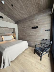 a bedroom with a bed and a black chair at Villa Sienna, Äkäslompolo, Ylläs in Äkäslompolo