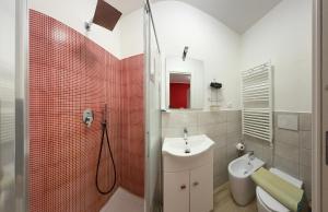 Un baño con lavabo, inodoro y ducha. en Alì Babà Rooms, en La Spezia