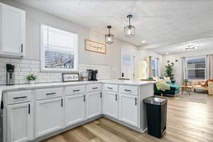 een keuken met witte kasten en een woonkamer bij Game Room Retreat with Firepit and Gym, Sleeps 12 in Indianapolis