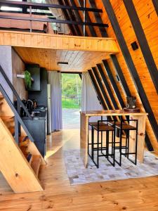 Una cocina abuhardillada con una mesa y una escalera. en Cold Land Chalé, en Urubici