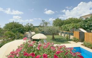 a patio with chairs and an umbrella and flowers at Villa Cvitan in Bašići
