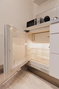 an empty kitchen with white cabinets and a refrigerator at Apartment Mostecka in Prague +13 photos
