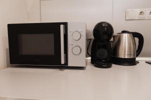 a microwave sitting on a counter next to a coffee maker at Apartment Mostecka in Prague