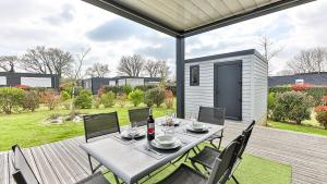 a table and chairs on a deck with a backyard at Havre lumineux pour se ressourcer et déconnecter - Bord de mer in Sainte-Foy +45 photos