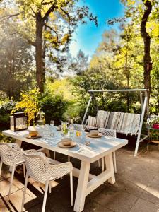 een witte tafel en stoelen op een patio bij Cottage Uylenhorst, De Witte Bergen 34 in IJhorst