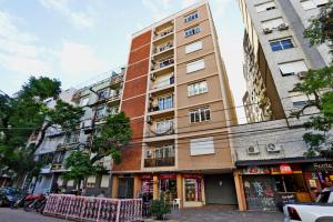 ein hohes Gebäude in einer Stadtstraße in der Unterkunft A 900 m da Redenção wi-fi 170 Mbps estilo e conforto na Cidade Baixa in Porto Alegre