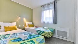a bedroom with two beds and a window at Havre lumineux pour se ressourcer et déconnecter - Bord de mer in Sainte-Foy