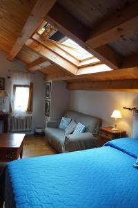 a bedroom with a bed and a couch in a room at La Casa del Glicine Tarzo in Fratta