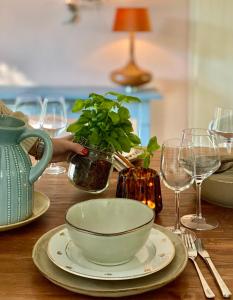 een tafel met een kom en borden en wijnglazen bij Cottage Uylenhorst, De Witte Bergen 34 in IJhorst