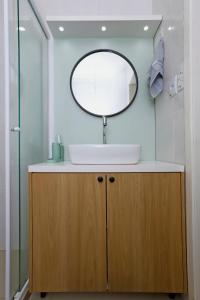 ein Badezimmer mit Waschbecken und Spiegel in der Unterkunft A 900 m da Redenção wi-fi 170 Mbps estilo e conforto na Cidade Baixa in Porto Alegre + 7 Fotos