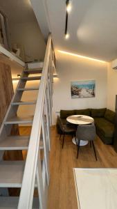 sala de estar con escalera, mesa y sofá en First Line Apartment 2, en Balchik