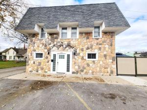 a stone house with a white door on a street at Charlies by the Bay Unit 4 in New Baltimore