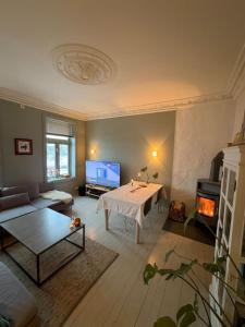 a living room with a table and a fireplace at Staymate 15 minutes from Barcode in Oslo