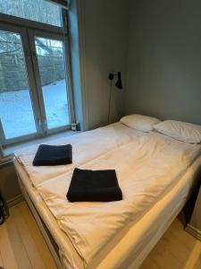 a large white bed with two black pillows on it at Staymate 15 minutes from Barcode in Oslo