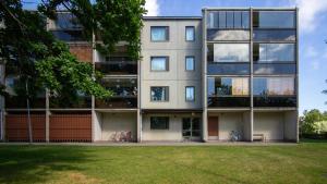 Un edificio de apartamentos con césped delante. en Central and Spacious Apartment for 4, en Hanko