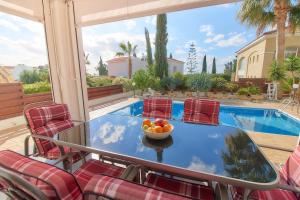 a table with a bowl of fruit on it on a patio at Cozy 3-BD Villa Natalia, Walk to Beach in Paphos