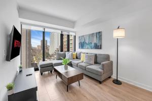 a living room with a couch and a table at Cozy Condo Near Restaurant TTC in Toronto