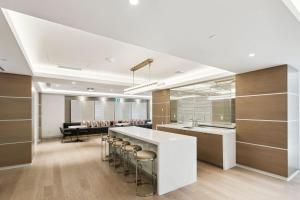 a kitchen with a counter and a bar with stools at Cozy Condo Near Restaurant TTC in Toronto +46 photos