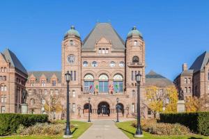 a large brick building with a clock on it at Cozy Condo Near Restaurant TTC in Toronto