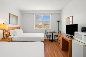 a hotel room with two beds and a television at Comfy Rockies Retreat for 4 Canmore DT Near Banff in Canmore
