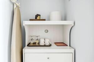 a white cabinet with a shelf and glasses on it at Serene 1BR Retreat Mtn Views, Pool, and Hot Tub in Canmore