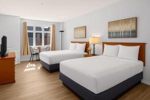 キャンモアにあるPerfect Canmore Getaway for 4 plus Exclusive Savingsのベッド2台とテレビがあるホテルの部屋