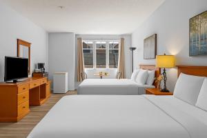 キャンモアにあるPerfect Canmore Getaway for 4 plus Exclusive Savingsのベッド2台と薄型テレビ付きのホテルの部屋