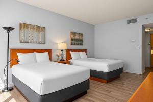 キャンモアにあるPerfect Canmore Getaway for 4 plus Exclusive Savingsのベッド2台とランプが備わったホテルの部屋