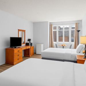キャンモアにあるPerfect Canmore Getaway for 4 plus Exclusive Savingsのベッドとテレビがあるホテルの部屋 +6枚の写真
